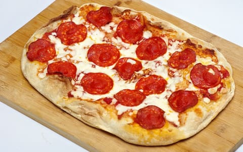 A pepperoni pizza on a board (product-neutral; not an official Papa John's photo)
