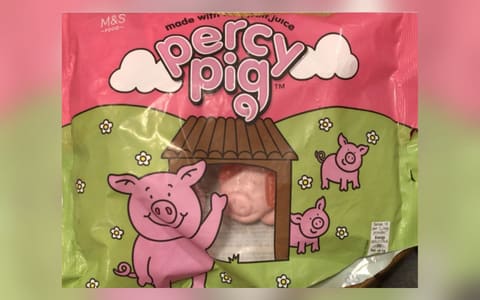 A bag of M&S Percy Pig fruit gums, showing pig-shaped sweets through a window