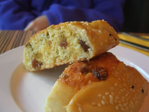 Sesame-crusted flaouna cut open to show a yellow cheese filling with raisins