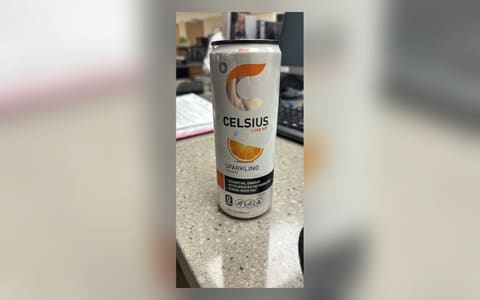 A can of Celsius Sparkling Orange energy drink on a desk