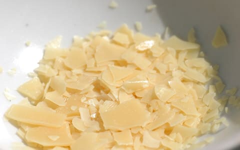 Flakes of carnauba wax in a dish, one of the glazing waxes this page covers