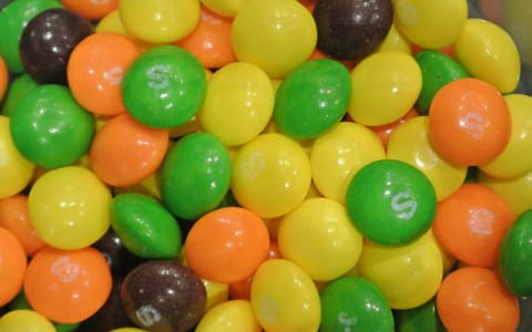 A close-up of Skittles in several colours