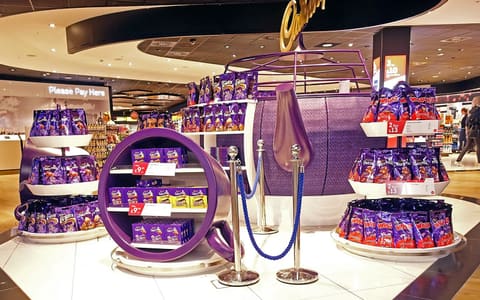 A Cadbury shop display stacked with purple Dairy Milk bars