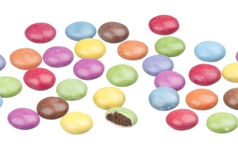 UK Smarties in assorted colours, one bitten to show the chocolate inside