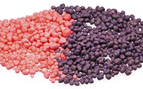 Strawberry and grape Nerds candy, poured side by side