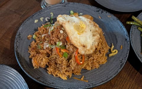 A plate of nasi goreng fried rice topped with a fried egg