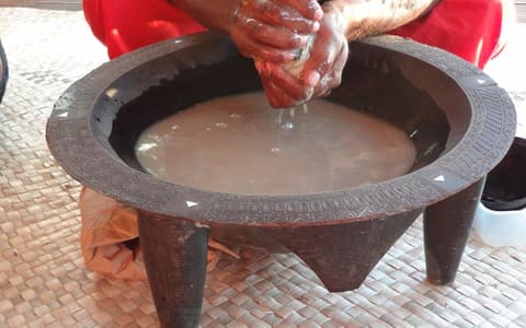 Kava being prepared by hand in a wooden kava bowl