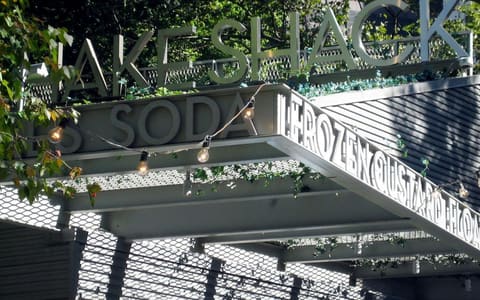 The Shake Shack sign above the original kiosk in Madison Square Park, New York