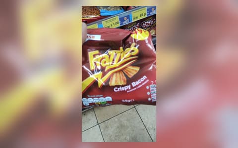 A 34 g bag of Smiths Frazzles crispy bacon flavour corn snacks held in a shop