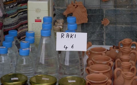 Bottles of clear Cretan raki (tsikoudia) for sale at a market stall