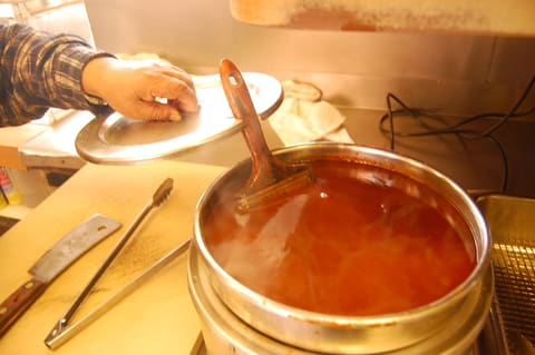 Dark brown basting sauce in a pot (product-neutral Worcestershire category)