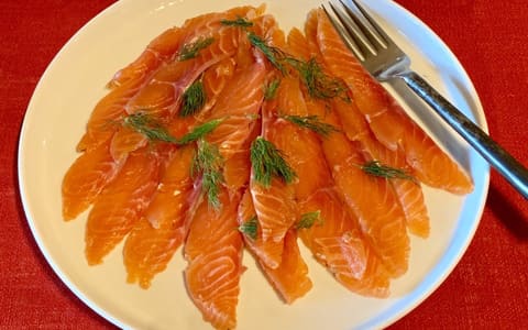 Thin slices of gravlax cured salmon with dill on a plate
