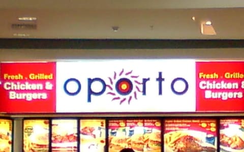 An Oporto food-court shopfront with the sign 'Fresh. Grilled Chicken & Burgers'