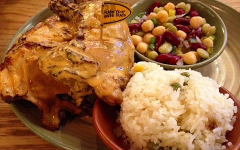 Flame-grilled peri-peri half chicken with spicy rice and a bean salad