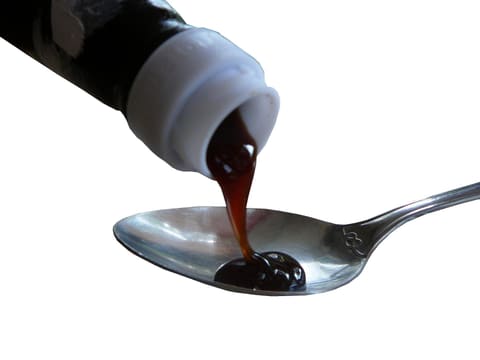 Dark viscous sauce (oyster-sauce category) poured onto a spoon, product-neutral