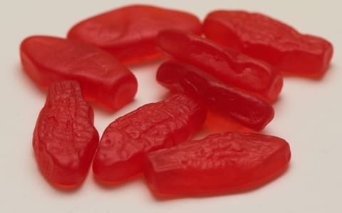 Red Swedish Fish chewy sweets on a white surface