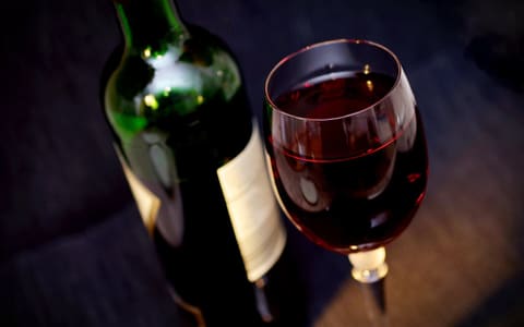 زجاجة وكأس من النبيذ الأحمر