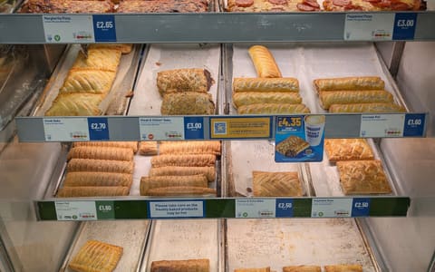 Trays of savoury bakes and pastries in a Greggs display counter