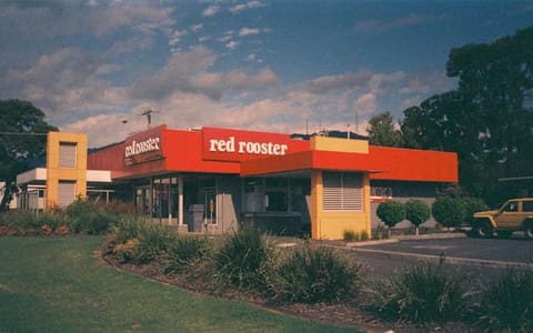 A Red Rooster restaurant with its red roof signage, in Australia